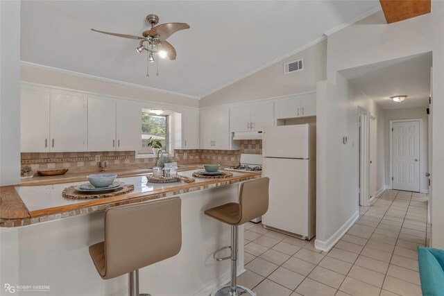 4102 Glen St, Bossier City, LA 71112 - kitchen with freestanding refrigerator, a ceiling fan, tasteful backsplash, light tile patterned flooring, and white cabinetry