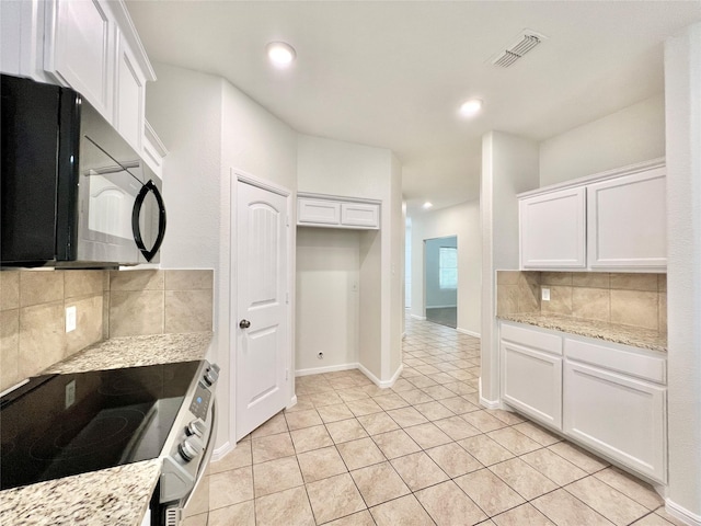 6940 Freeboard Way, Fort Worth, TX 76179 - kitchen featuring stainless steel electric range oven, black microwave, decorative backsplash, white cabinets, and light tile patterned floors
