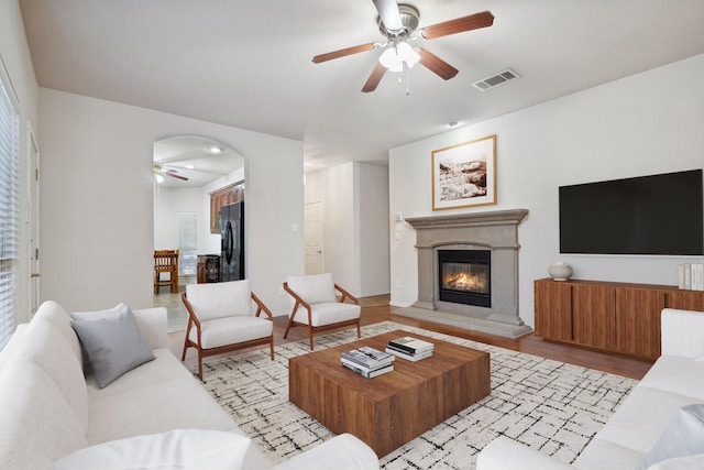 6132 Farrah Dr, Fort Worth, TX 76131 - living area with a ceiling fan, a glass covered fireplace, light wood-style floors, and arched walkways