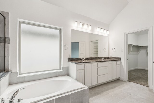 906 Overton Ave, Celina, TX 75009 - full bathroom featuring a garden tub, double vanity, a spacious closet, lofted ceiling, and tile patterned flooring