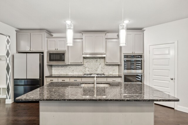 906 Overton Ave, Celina, TX 75009 - kitchen with appliances with stainless steel finishes, a sink, decorative backsplash, baseboards, and a kitchen island with sink