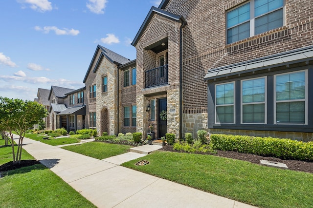 317 Mcconathy Way, Flower Mound, TX 75028 - view of front of house featuring brick siding, a front yard, a residential view, and a balcony