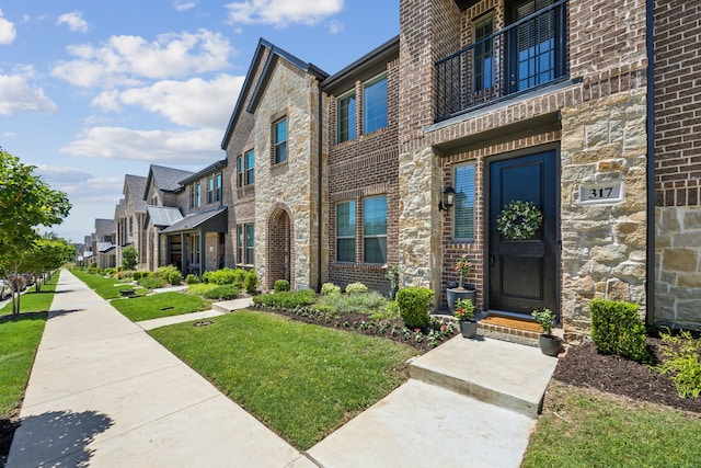 317 Mcconathy Way, Flower Mound, TX 75028 - entrance to property with a residential view, brick siding, a lawn, and stone siding