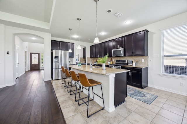 1901 Brahorn Ln, Fort Worth, TX 76131 - kitchen featuring appliances with stainless steel finishes, a breakfast bar, healthy amount of natural light, light stone countertops, and recessed lighting