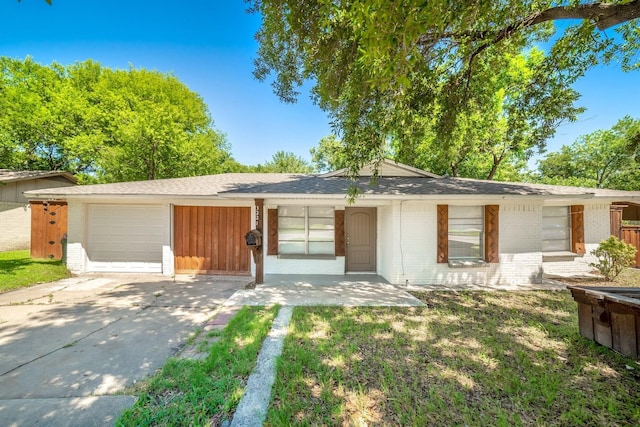 3221 Moon Dr, Mesquite, TX 75150 - ranch-style house with brick siding, an attached garage, concrete driveway, a front lawn, and roof with shingles