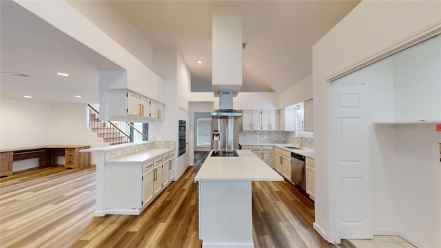 4917 Meadow Vista Pl, Garland, TX 75043 - kitchen with appliances with stainless steel finishes, backsplash, light countertops, a kitchen island, and wood finished floors