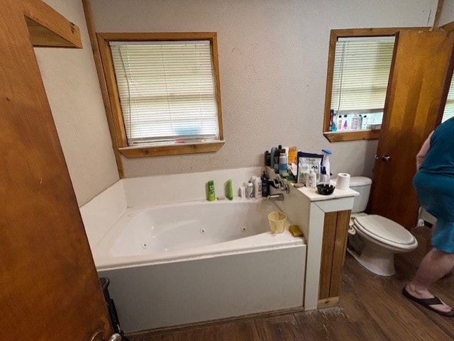 4132 Fm 546, Princeton, TX 75407 - bathroom with wood finished floors, a jetted tub, toilet, and healthy amount of natural light