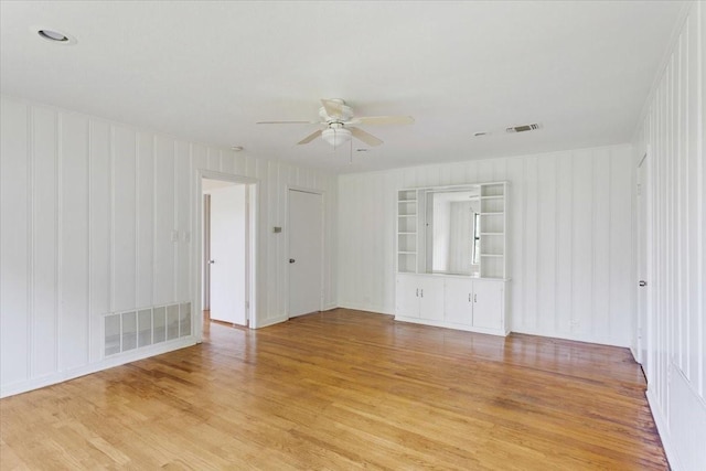 104 Mackinnon, Mount Pleasant, TX 75455 - spare room with light wood-style floors, a ceiling fan, and a decorative wall