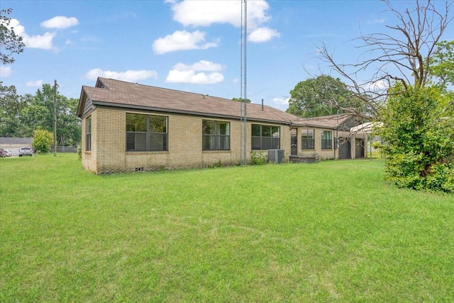 104 Mackinnon, Mount Pleasant, TX 75455 - rear view of property featuring brick siding, a lawn, central air condition unit, and a shingled roof