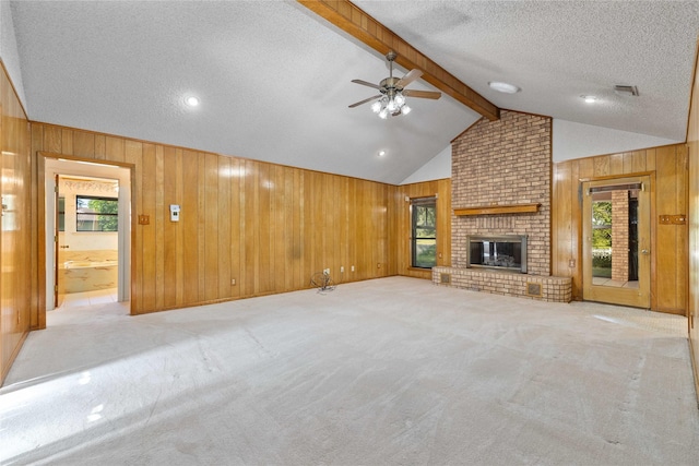 1025 S Lamar St, De Leon, TX 76444 - unfurnished living room featuring wood walls, a textured ceiling, plenty of natural light, light carpet, and a ceiling fan