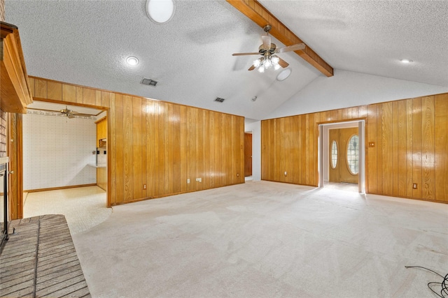 1025 S Lamar St, De Leon, TX 76444 - unfurnished living room with wooden walls, light carpet, a textured ceiling, and a ceiling fan