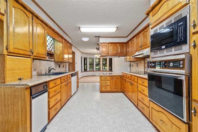 1025 S Lamar St, De Leon, TX 76444 - kitchen featuring appliances with stainless steel finishes, a textured ceiling, a sink, decorative backsplash, and brown cabinets