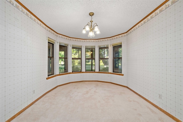 1025 S Lamar St, De Leon, TX 76444 - empty room with crown molding, baseboards, a chandelier, carpet flooring, and a textured ceiling