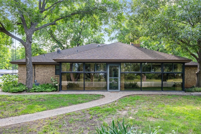 1025 S Lamar St, De Leon, TX 76444 - rear view of property featuring roof with shingles, brick siding, a yard, and a chimney