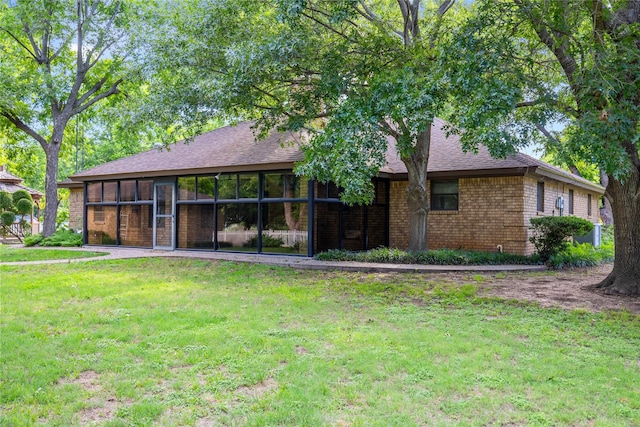 1025 S Lamar St, De Leon, TX 76444 - rear view of property featuring a yard, brick siding, a sunroom, and roof with shingles