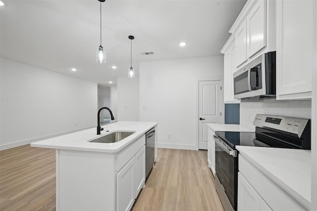 2738 W Washington St, Denison, TX 75020 - kitchen with appliances with stainless steel finishes, a sink, light wood-style flooring, light countertops, and recessed lighting