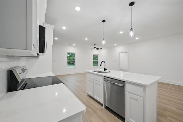 2738 W Washington St, Denison, TX 75020 - kitchen with appliances with stainless steel finishes, a sink, open floor plan, light wood finished floors, and a kitchen island with sink