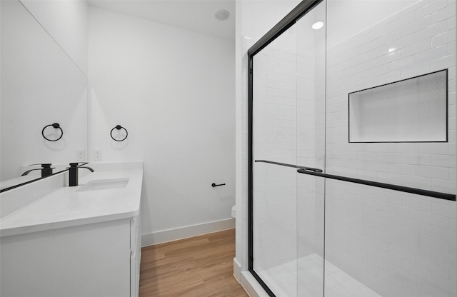 2738 W Washington St, Denison, TX 75020 - full bath featuring double vanity, a stall shower, toilet, and wood finished floors