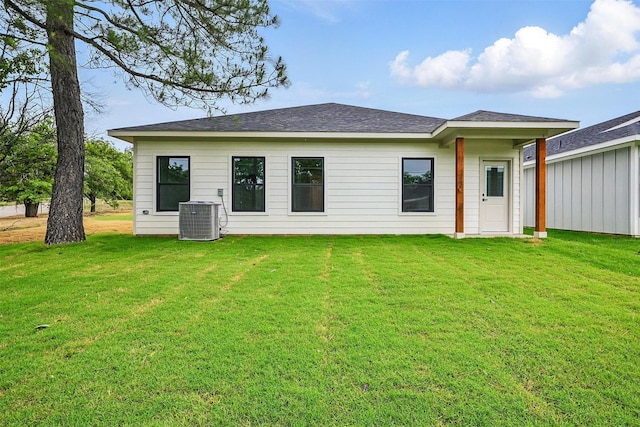 2738 W Washington St, Denison, TX 75020 - back of house with a yard, central AC unit, and roof with shingles
