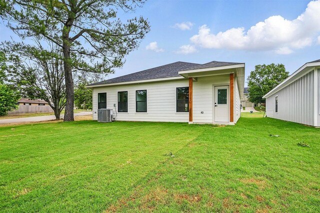 2738 W Washington St, Denison, TX 75020 - back of property featuring central AC, a lawn, and roof with shingles