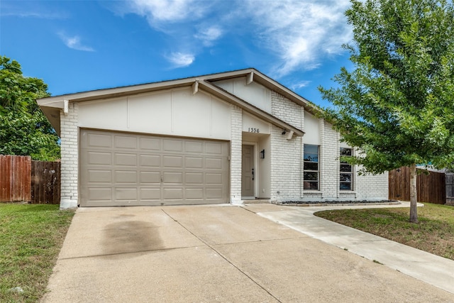 1336 Whittenburg Dr, Fort Worth, TX 76134 - view of front of home featuring brick siding, driveway, and an attached garage