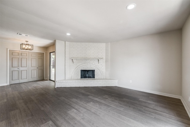 1336 Whittenburg Dr, Fort Worth, TX 76134 - unfurnished living room with a chandelier, baseboards, dark wood-type flooring, recessed lighting, and a fireplace