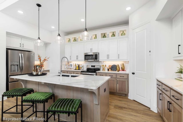 8409 Peach St, Justin, TX 76247 - kitchen with stainless steel appliances, a sink, backsplash, glass insert cabinets, and a breakfast bar area