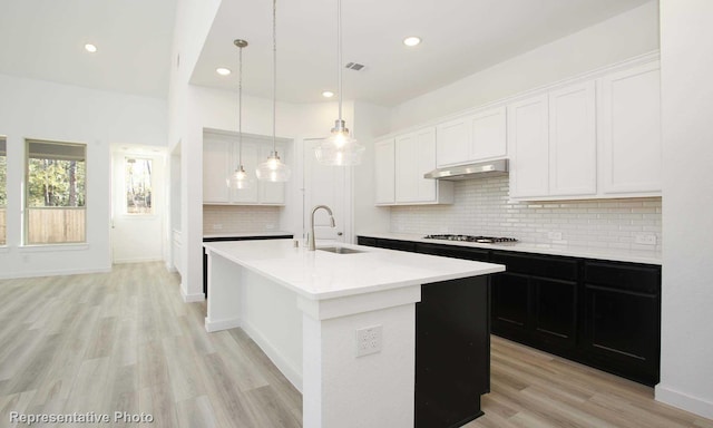 8409 Peach St, Justin, TX 76247 - kitchen with a sink, light countertops, white cabinets, a kitchen island with sink, and recessed lighting