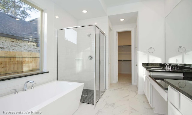 8409 Peach St, Justin, TX 76247 - full bath featuring marble finish floors, a stall shower, a soaking tub, vanity, and recessed lighting