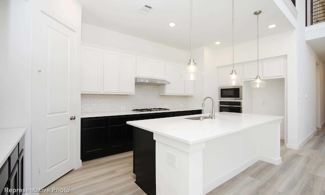 8409 Peach St, Justin, TX 76247 - kitchen with a sink, under cabinet range hood, gas stovetop, decorative backsplash, and light wood-style floors