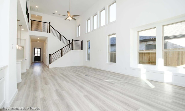 8409 Peach St, Justin, TX 76247 - unfurnished living room featuring stairway, light wood-type flooring, a high ceiling, ceiling fan, and recessed lighting
