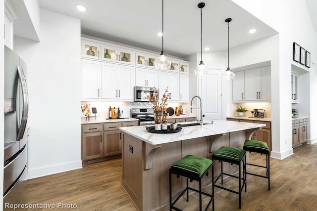 8409 Peach St, Justin, TX 76247 - kitchen with stainless steel appliances, a breakfast bar area, dark wood-style floors, a sink, and baseboards