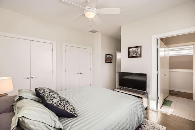 1115 Crownview Ln, Dallas, TX 75208 - bedroom featuring wood finished floors, two closets, a ceiling fan, and baseboards