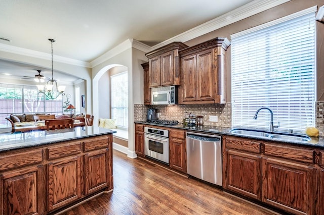 5946 Wallis Dr, Frisco, TX 75033 - kitchen featuring appliances with stainless steel finishes, a sink, dark wood-type flooring, decorative backsplash, and ceiling fan