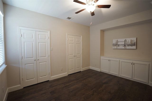 720 Madeline Ct, Azle, TX 76020 - unfurnished bedroom featuring dark wood-style floors, multiple closets, baseboards, and ceiling fan