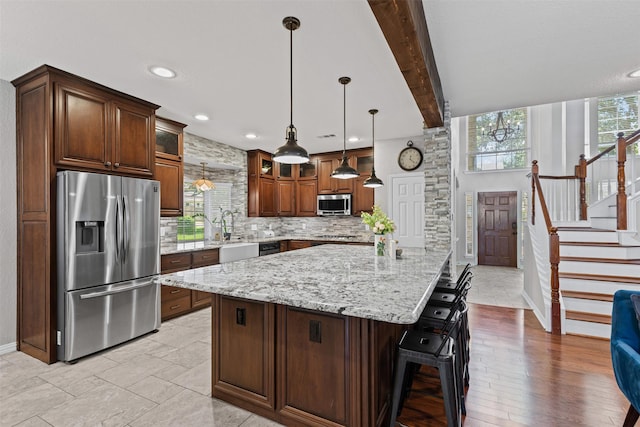 5655 Redgum Dr, Fort Worth, TX 76244 - kitchen with stainless steel appliances, baseboards, backsplash, light stone counters, and glass insert cabinets
