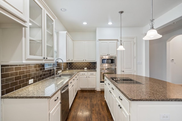 546 El Camino Dr, Frisco, TX 75036 - kitchen with stainless steel appliances, a sink, a center island, dark wood-style flooring, and backsplash