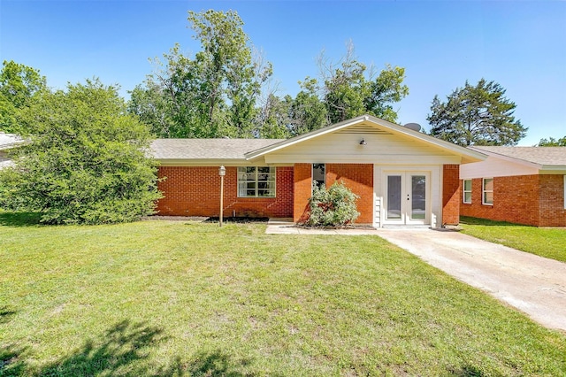 1309 Manor Dr, Cleburne, TX 76033 - ranch-style home with french doors, a front lawn, brick siding, and driveway