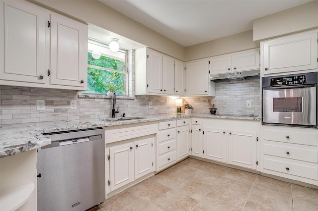 1309 Manor Dr, Cleburne, TX 76033 - kitchen with stainless steel appliances, a sink, decorative backsplash, and white cabinets