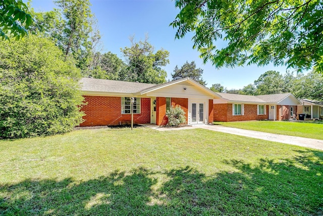 1309 Manor Dr, Cleburne, TX 76033 - ranch-style house with french doors, a front lawn, brick siding, and concrete driveway