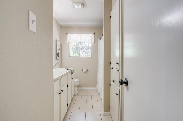 1309 Manor Dr, Cleburne, TX 76033 - full bath with toilet, vanity, tile patterned flooring, baseboards, and a shower with curtain