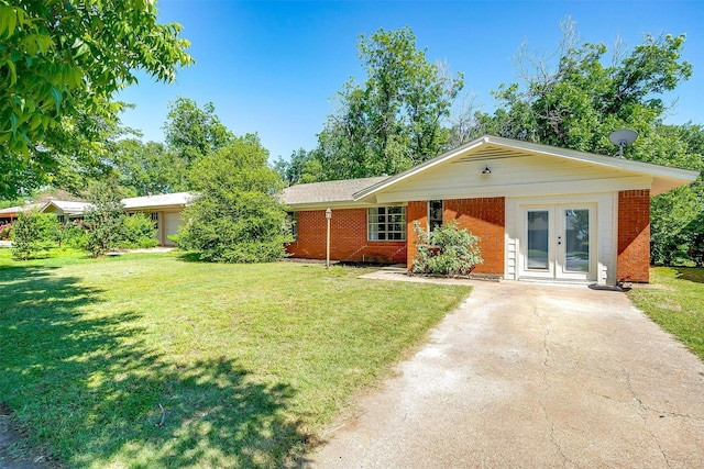 1309 Manor Dr, Cleburne, TX 76033 - ranch-style home with brick siding, french doors, driveway, and a front lawn
