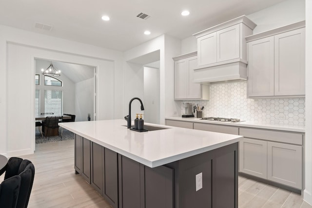 2316 Lazy Dog Ln, Northlake, TX 76247 - kitchen with a sink, a kitchen island with sink, backsplash, a chandelier, and light countertops