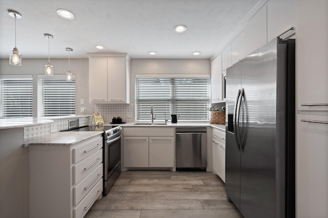 2645 Forest Grove Dr, Richardson, TX 75080 - kitchen featuring appliances with stainless steel finishes, a peninsula, a sink, light wood-style floors, and tasteful backsplash