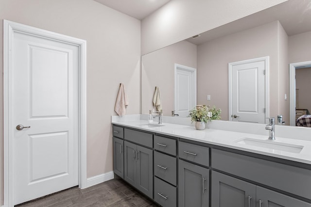 601 Big Horn Pass, Denton, TX 76210 - full bathroom with double vanity, wood finished floors, and baseboards