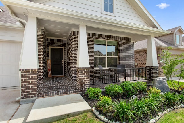601 Big Horn Pass, Denton, TX 76210 - entrance to property featuring a porch, brick siding, and an attached garage