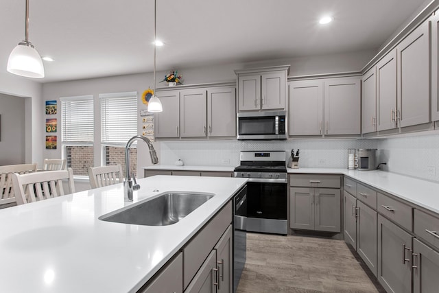 601 Big Horn Pass, Denton, TX 76210 - kitchen with stainless steel appliances, gray cabinets, a sink, decorative backsplash, and light countertops