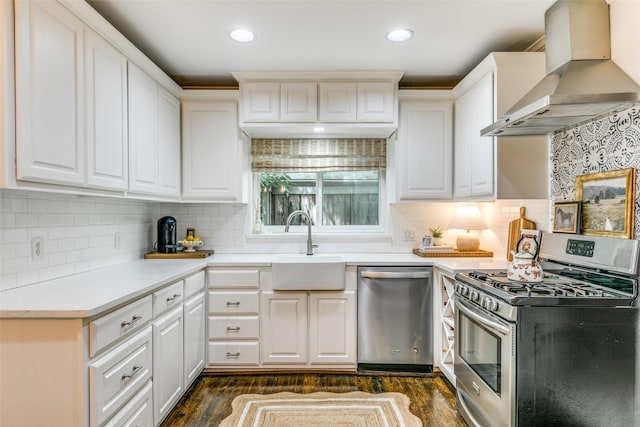 5022 W Hanover Ave, Dallas, TX 75209 - kitchen featuring stainless steel appliances, wall chimney exhaust hood, a sink, dark wood-style floors, and tasteful backsplash