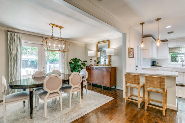5022 W Hanover Ave, Dallas, TX 75209 - dining room with dark wood-style flooring, plenty of natural light, crown molding, a chandelier, and baseboards