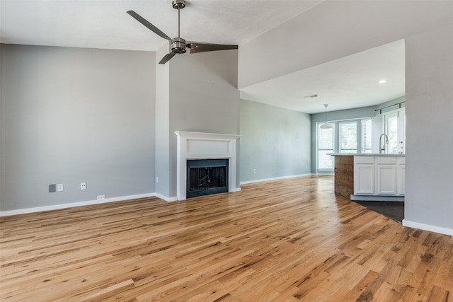 630 W Canty St Unit B6, Dallas, TX 75208 - unfurnished living room featuring light wood-style flooring, baseboards, ceiling fan, a fireplace, and recessed lighting